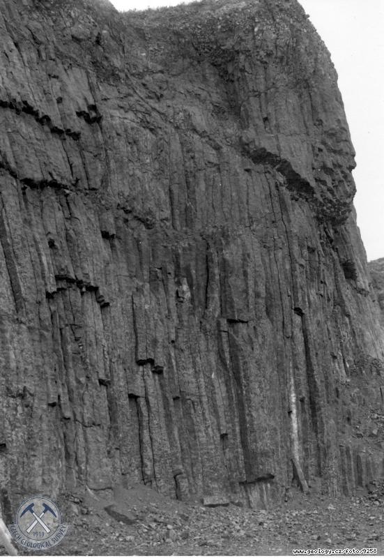 Fotografie : Sklovit nefelinit. Lomov stna se svisle orientovanou sloupovitou odlunost., Hemanice