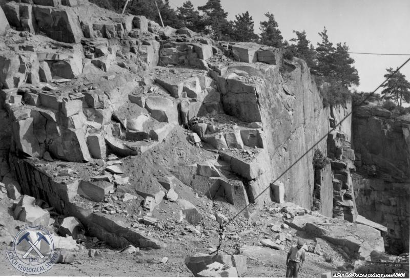 Fotografie : Lom �.023Z�pado�esk.kamenopr�m. v Blatn�. Amfibolicko-biotitick� granodiorit,�t�novick� �ula. Lom vznikl spojen�m vy���ho st�nov�ho (vlevo) a j�mov�ho(vpravo). Zvl᚝ v�razn� je tu �ikm� lo�n� od., �t�novice