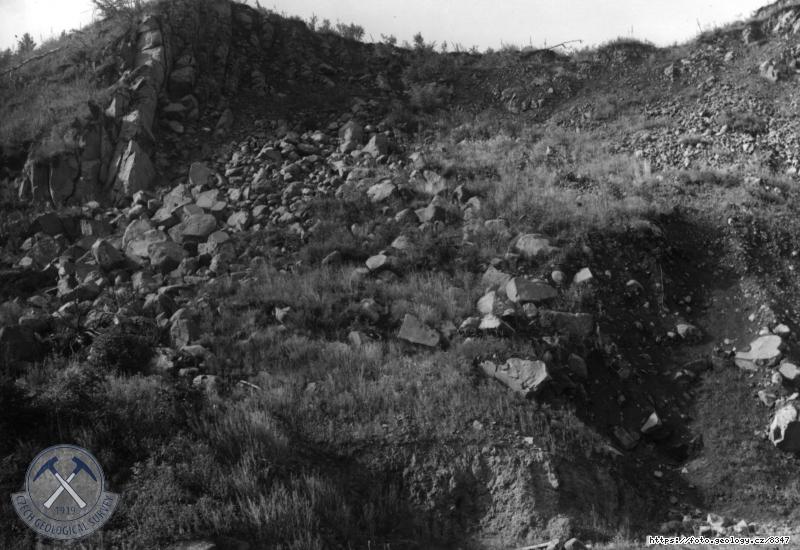 Fotografie Lom v nefelinick�m tefritu: Nefelinick� tefrit. Lev� ��st lomu, naho�e sloupovit� odlu�nost, dole v mal� odkopan� st�n� tuf., Vl�� Hora