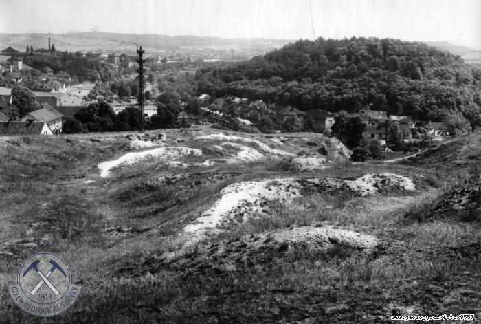 Fotografie : V popředí lom v křemencovém hřbetu přerušený zaříznutou Rokytkou, pokračující zalesněným vrchem Smetánkou v pozadí, Hrdlořezy